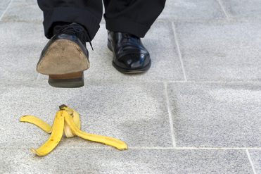 Businessman stepping on banana skin, copy space Businessman stepping on banana skin, copy space